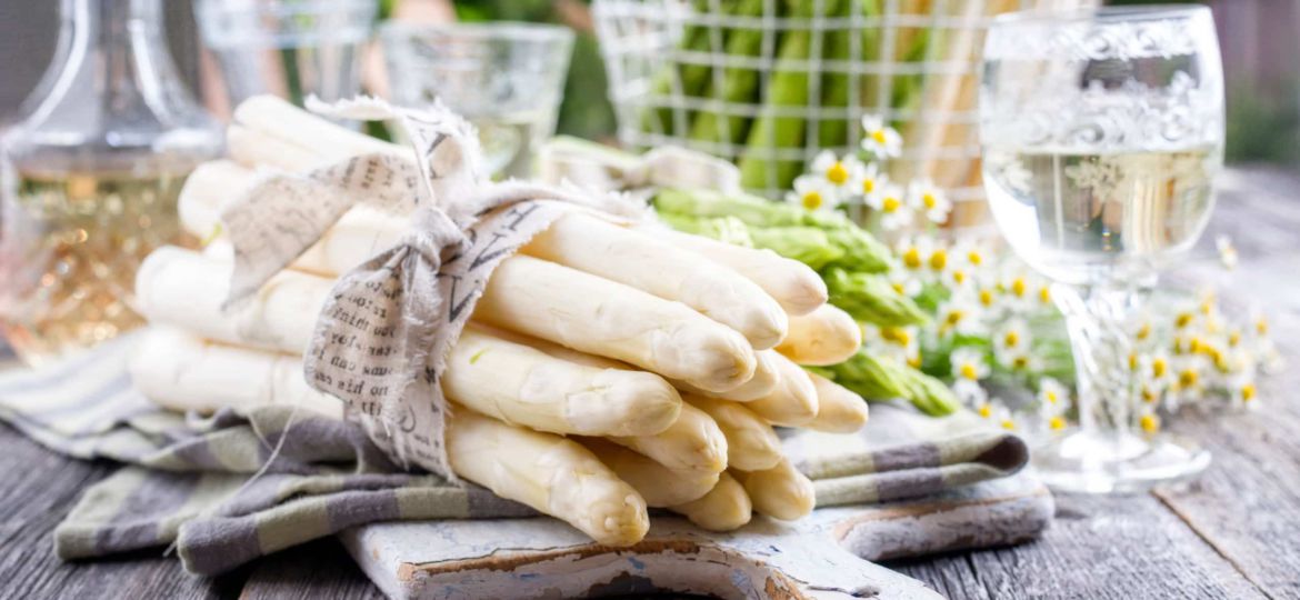 Roher grüner und weißer Spargel als Close-up auf Schneidebrett