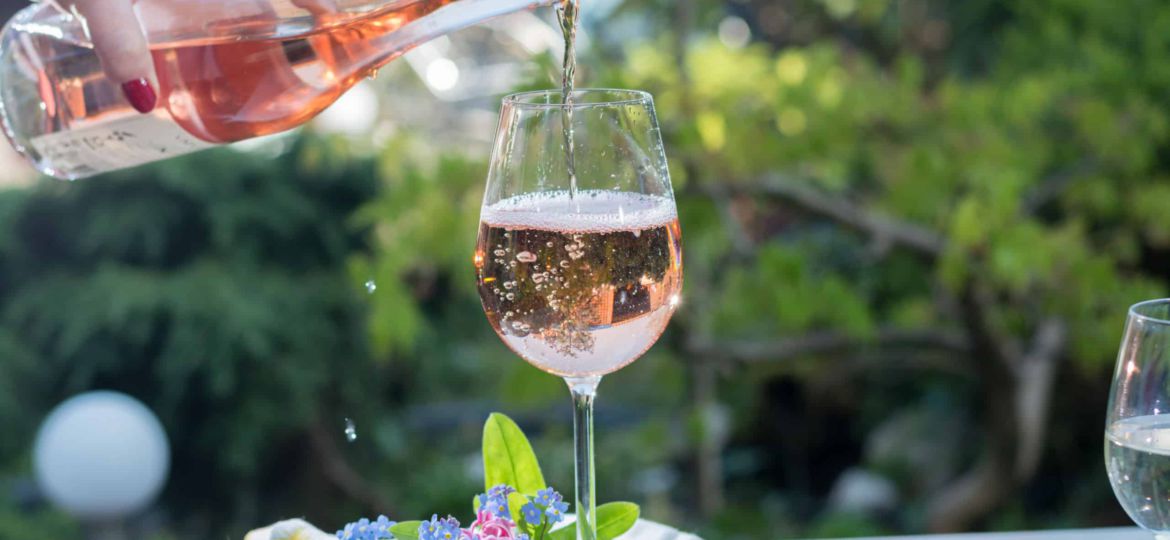 Waiter pouring a glas of cold rose wine, outdoor terrase, sunny