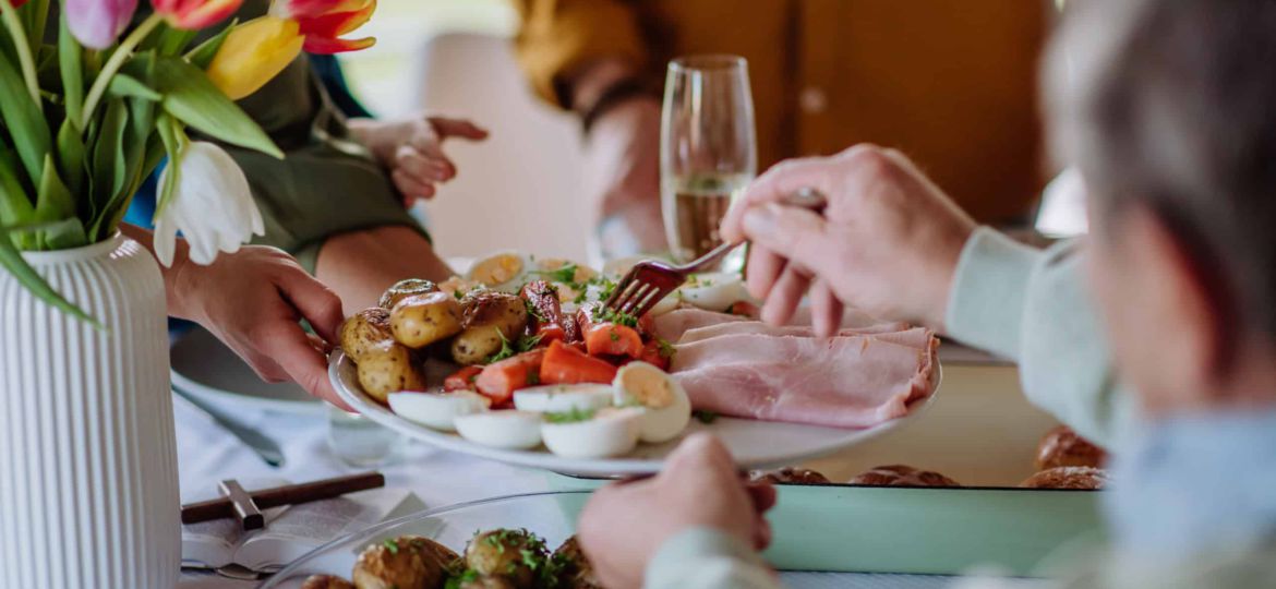 Close up of muligenerational family serving Easter dinner together.