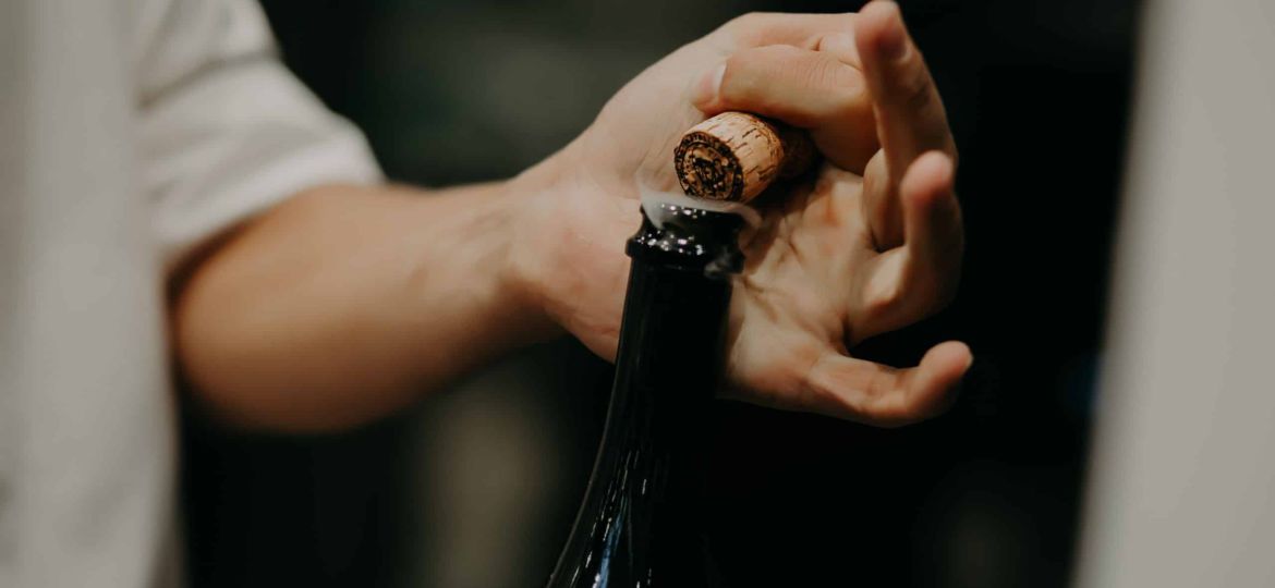 Sommelier opening wine bottle in the wine cellar